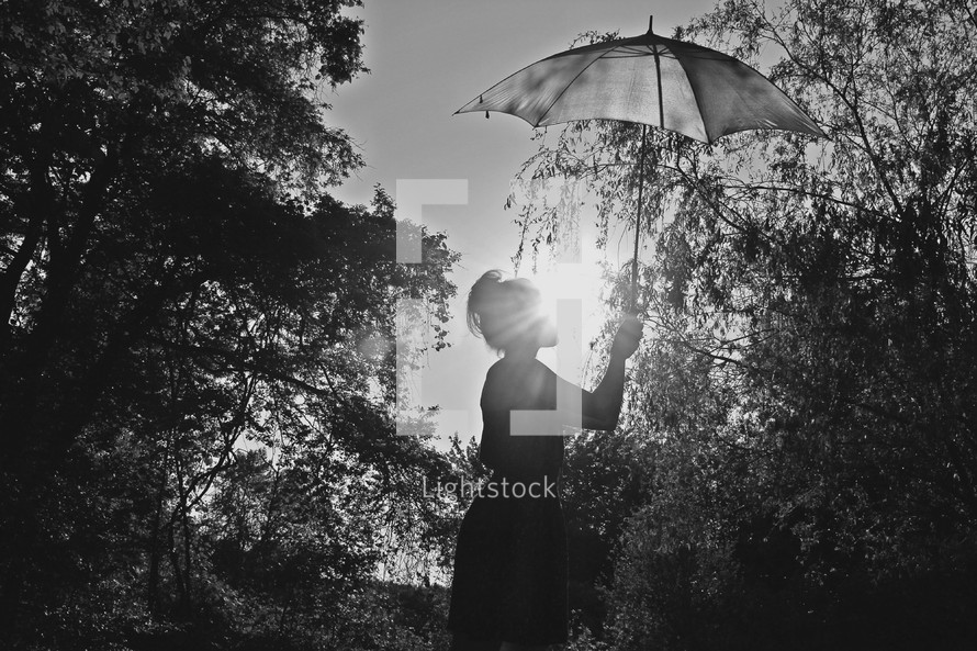 woman holding up and umbrella to block the sun