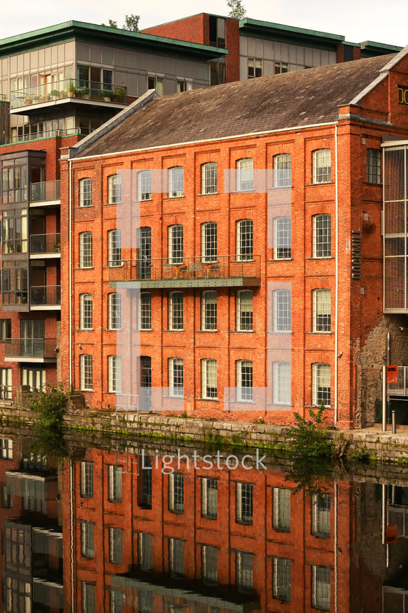 reflection over water of a brick building 