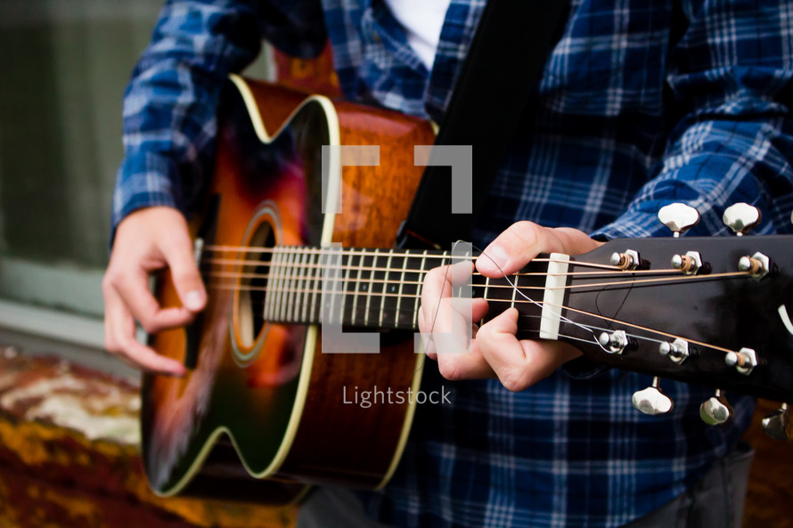 a man's hands on a guitar 
