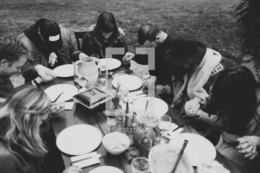 prayer at a fall dinner party outdoors 
