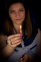 girl holding a lit match