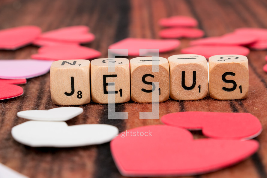 word Jesus in scrabble pieces and a paper heart 