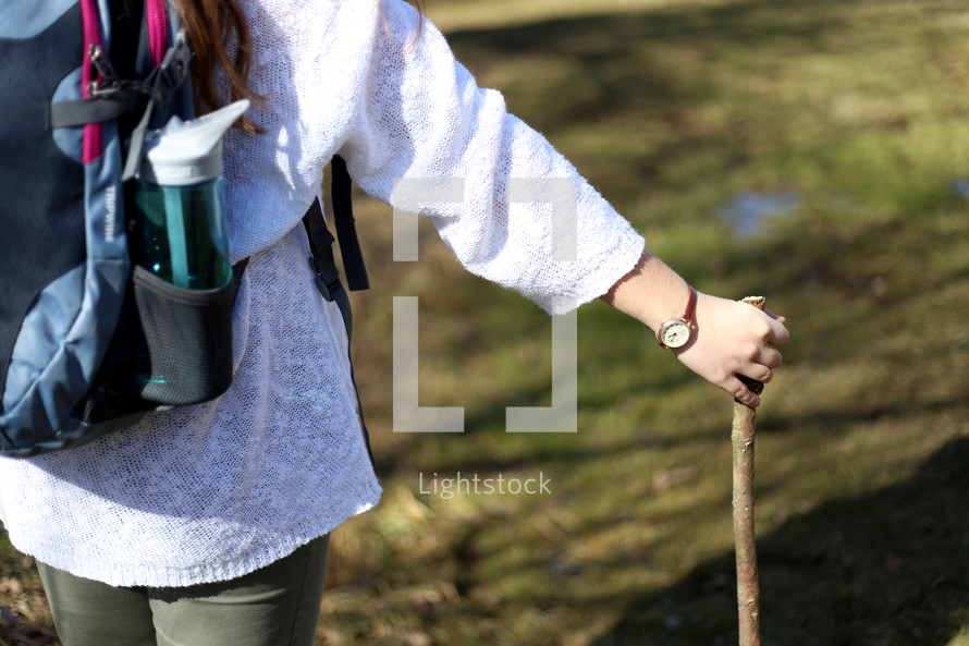 woman backpacking with a walking stick 