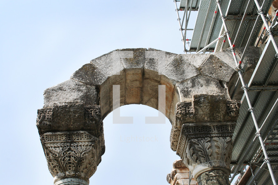 scaffolding and ancient columns with arch 