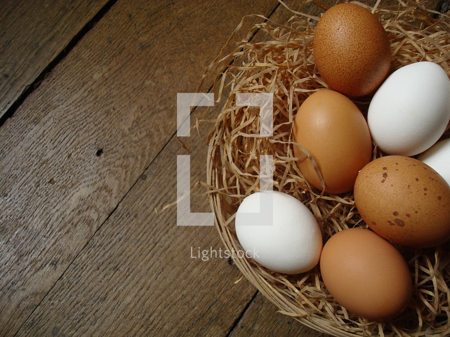 Natural eggs in a basket on a wooden floor.