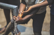 children washing hands in running water 