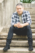 portrait of a Latino man sitting on steps 