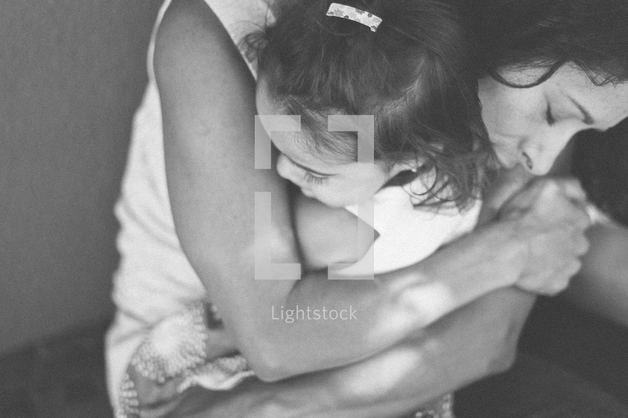 A mother hugging her daughter. 