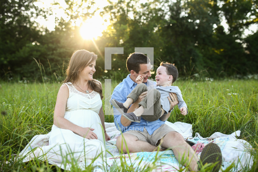 a family sitting in the grass 