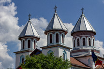 Details of the ornate cupolas on an orthodox church in the village of Blăjel, Romania under a blue sky