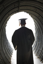 graduate walking through a tunnel