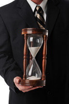businessman holding a sand hourglass timer 