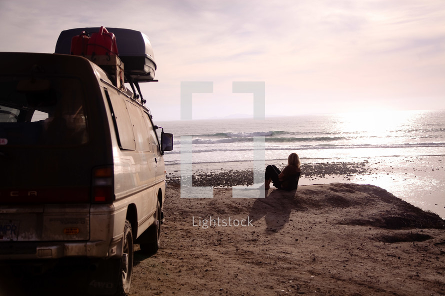 woman and van on a beach 