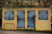 closed doors and shutters on a yellow shanty 