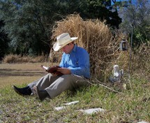 A man takes time from his chores in a rural country setting to study the word of God and read his bible, meditating on its truth and reflecting on the peace of God's promises. No matter how busy we get, we should and need to always stay in the word. It keeps us focused on our faith, the promises of God and the living truth of His word. 