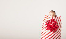 A man covered by wrapping paper and bow