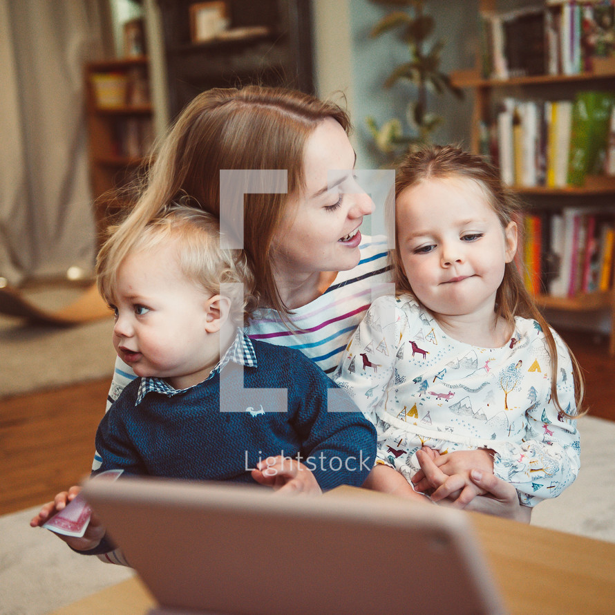 mother and children talking with family through video conference on a computer 