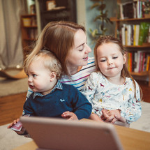 mother and children talking with family through video conference on a computer 