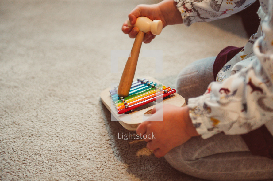 child playing with toys on the carpet 