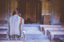 a woman sitting alone in a church 