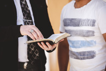 a man reading a Bible to a stranger 