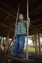 Boy standing on swing