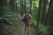 men backpacking through a forest 