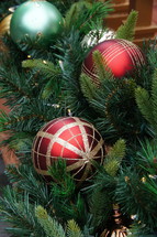 Red, gold and green ball Christmas ornaments with pine branch.