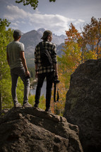 men standing on rocks in a fall forest 