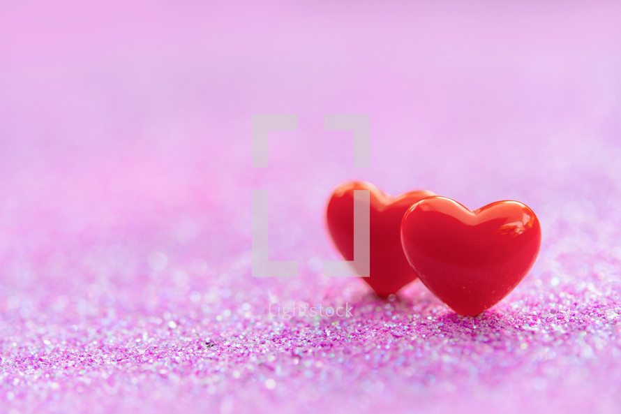 two red hearts on a pink background 