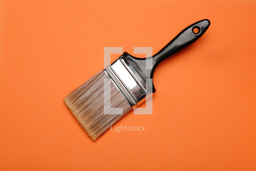 Paintbrush on an orange background.