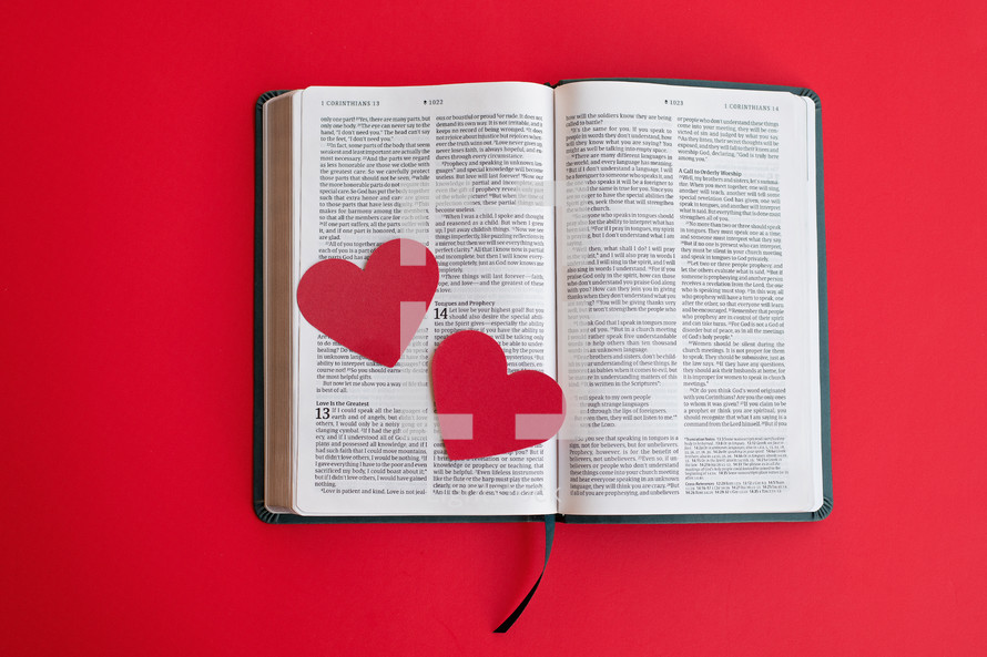 Two red hearts on an open Bible 