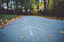 arrow drawn on a paved path 