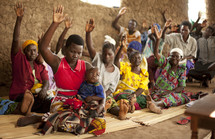A group of Ugandan women lift their hands in prayer