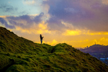 man standing on a green mountain top 