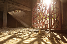 sun shining through lattice windows onto a dirt floor room