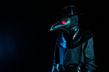Portrait Of Plague Doctor With Crow-Like Mask And Red Eyes Isolated On Black