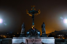 Significant monument - statue of crucified Christ on Charles bridge in Prague at night. 17th Century crucifixion statue with Hebrew lettering. Old town. High quality photo