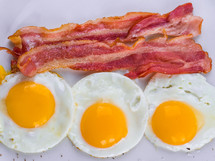 Fried egg with bacon on white plate. Delicious colorful English breakfast. High quality photo