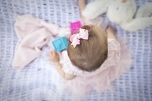 Infant baby girl playing on blanket