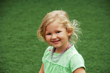 a smiling girl child outdoors 