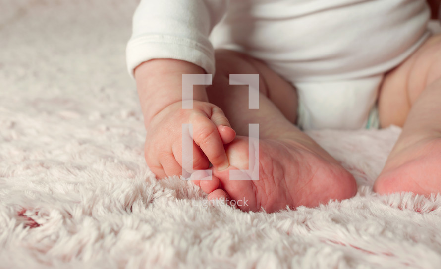 infant girl on a pink rug 