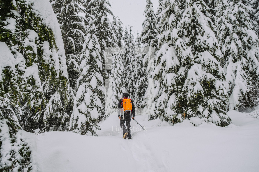 A man backpacking in snow. 