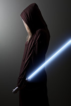 Jedi Guardian; woman in brown robe holding a blue lightsaber.