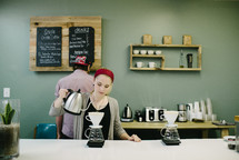 barista brewing coffee behind the counter 