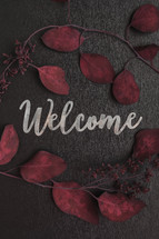 welcome and red fall leaves on a black background 