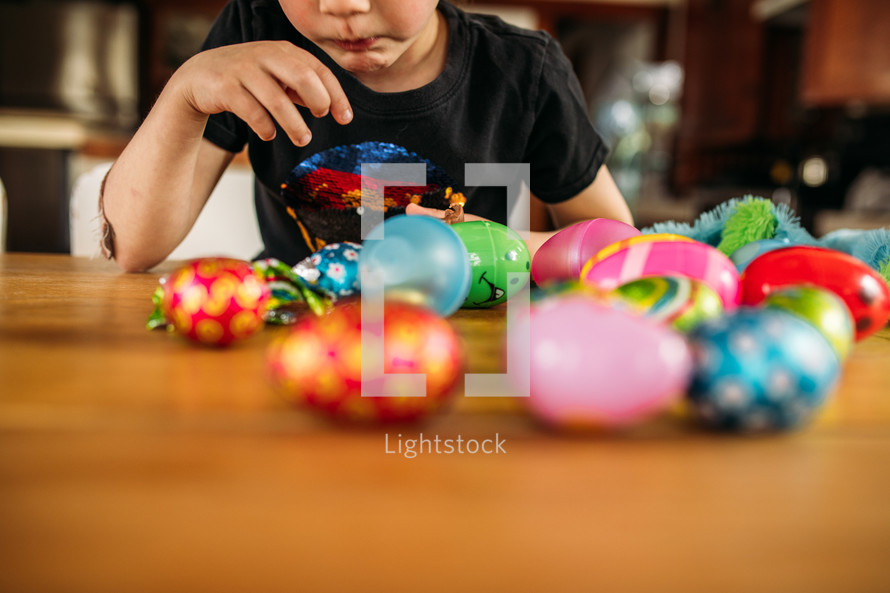 child eating candy out of Easter eggs 