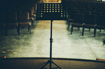 Music stand on stage in empty auditorium.