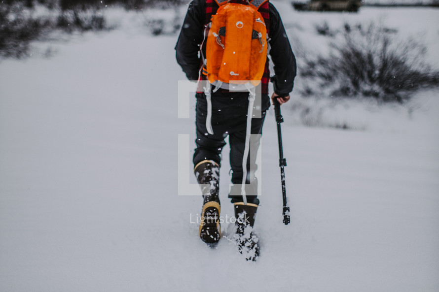 A man backpacking through snow. 