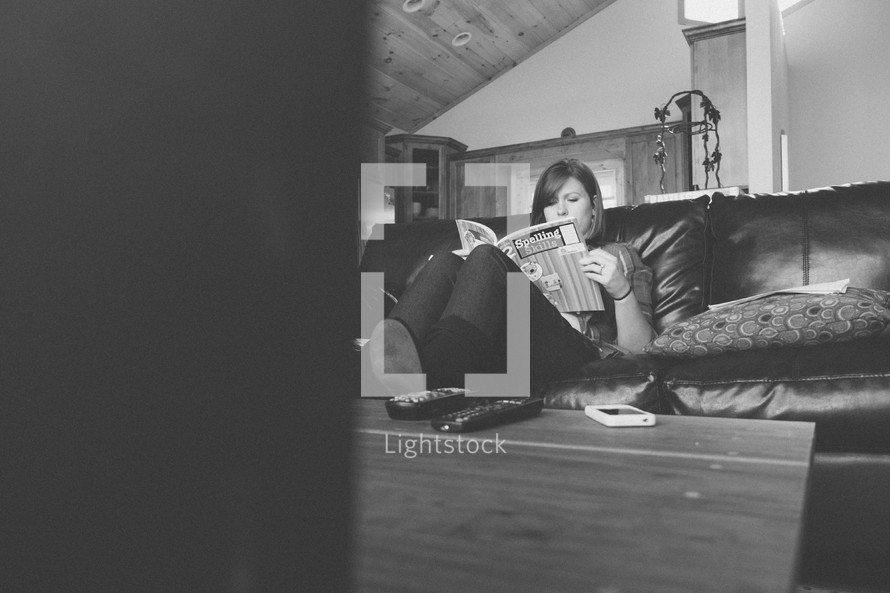 woman sitting on a couch reading 